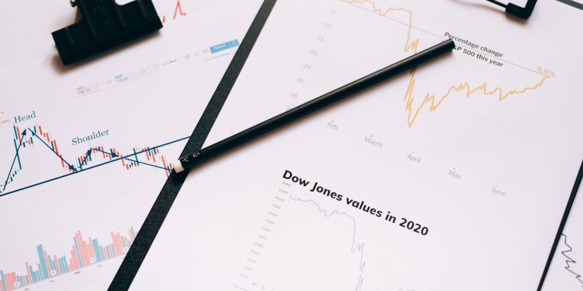 Clipboard with stock market charts and graphs representing financial data analysis.