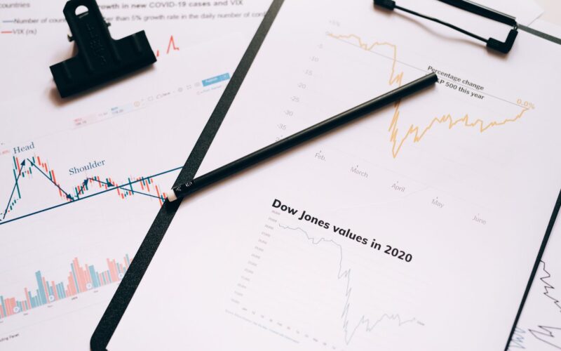 Clipboard with stock market charts and graphs representing financial data analysis.