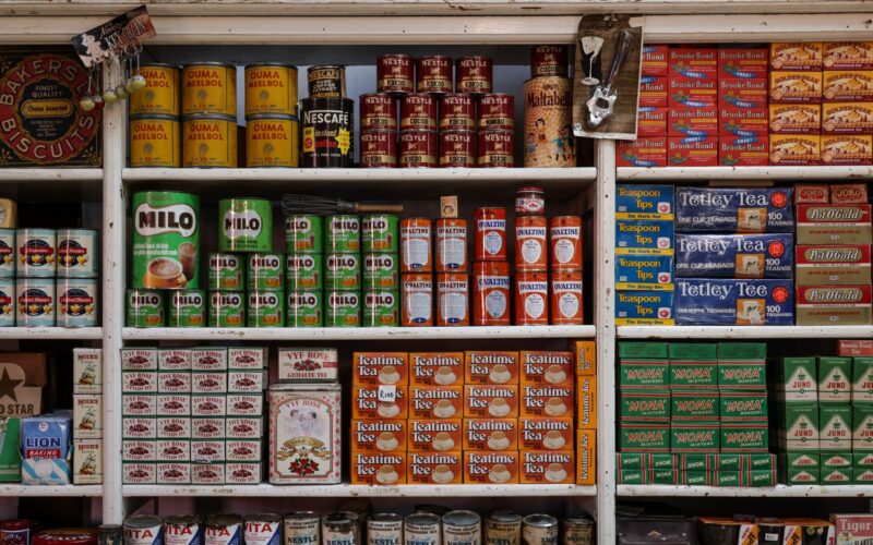 A nostalgic view of vintage grocery store shelves filled with assorted food products and drinks.