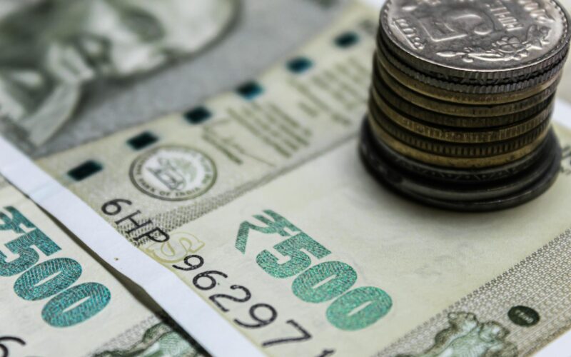 Detailed view of Indian rupees and stacked coins, representing currency and finance.