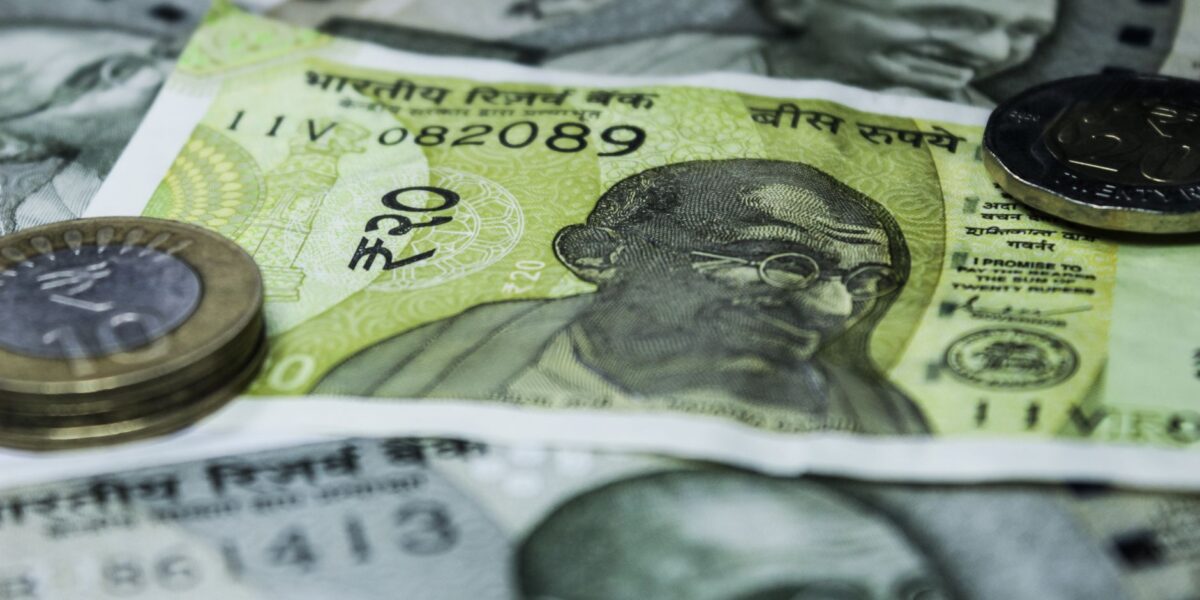 Close-up shot of Indian currency notes and coins, highlighting economic themes.