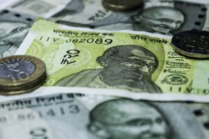 Close-up shot of Indian currency notes and coins, highlighting economic themes.