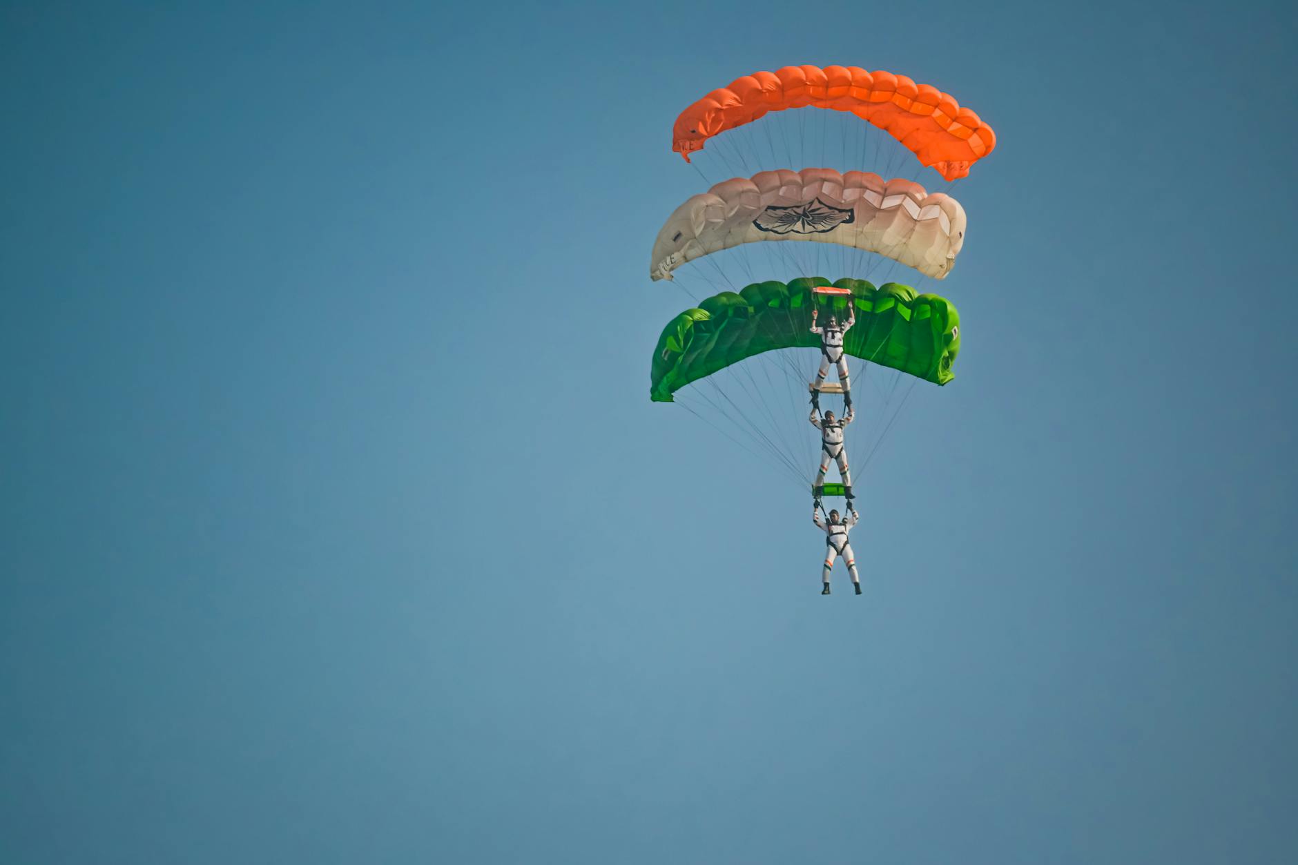 Spectacular trio skydiving display with tricolor parachutes in Kolkata, India.