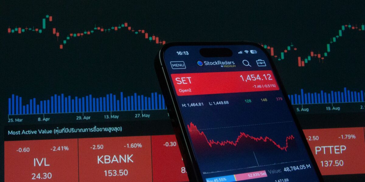 Mobile app showing stock market data with charts on screen.