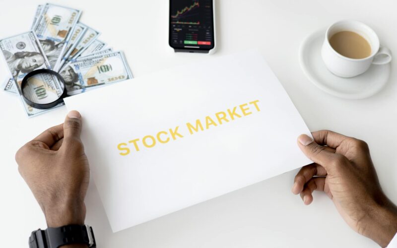 Business theme with stock market document, currency, and mobile display.