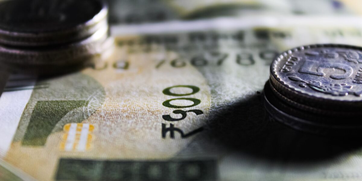 Detailed close-up of Indian rupee notes and coins showcasing currency design.