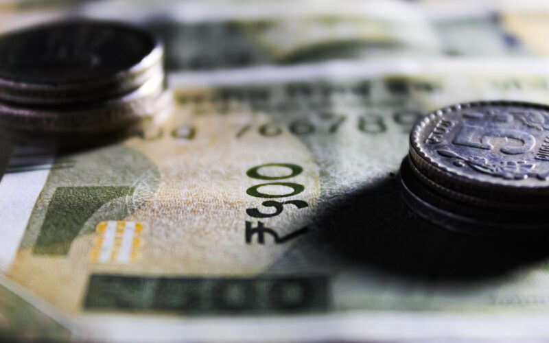 Detailed close-up of Indian rupee notes and coins showcasing currency design.