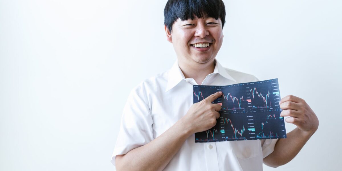 Smiling man presenting cryptocurrency investment chart indoors.