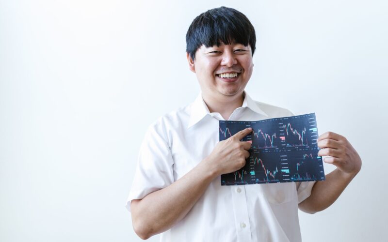 Smiling man presenting cryptocurrency investment chart indoors.