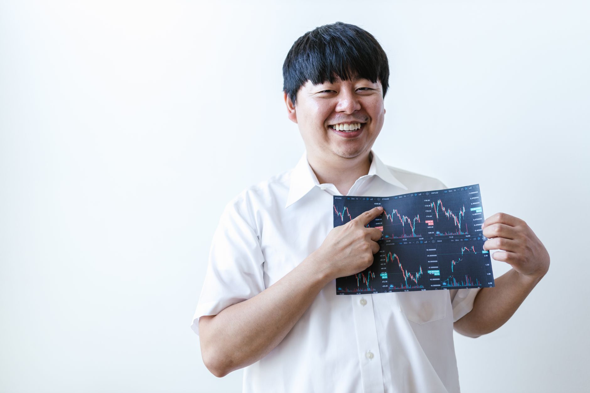 Smiling man presenting cryptocurrency investment chart indoors.
