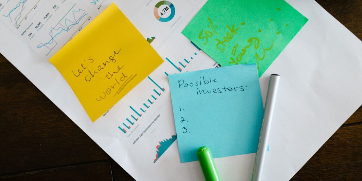 Startup brainstorming with charts, colorful sticky notes, and planning strategies for success.