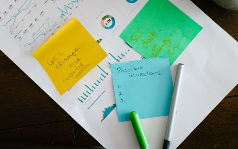 Startup brainstorming with charts, colorful sticky notes, and planning strategies for success.