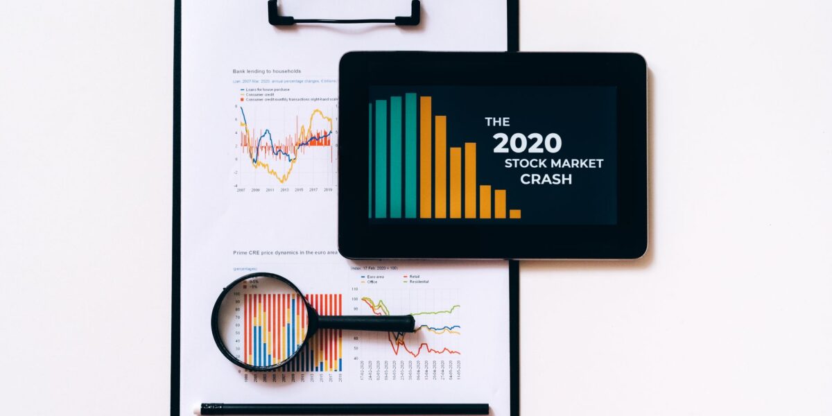 Tablet and clipboard with charts illustrating the 2020 stock market crash.
