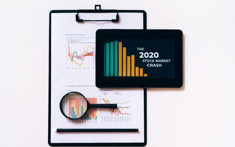 Tablet and clipboard with charts illustrating the 2020 stock market crash.