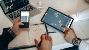 Business professionals analyzing charts on digital devices during a meeting.