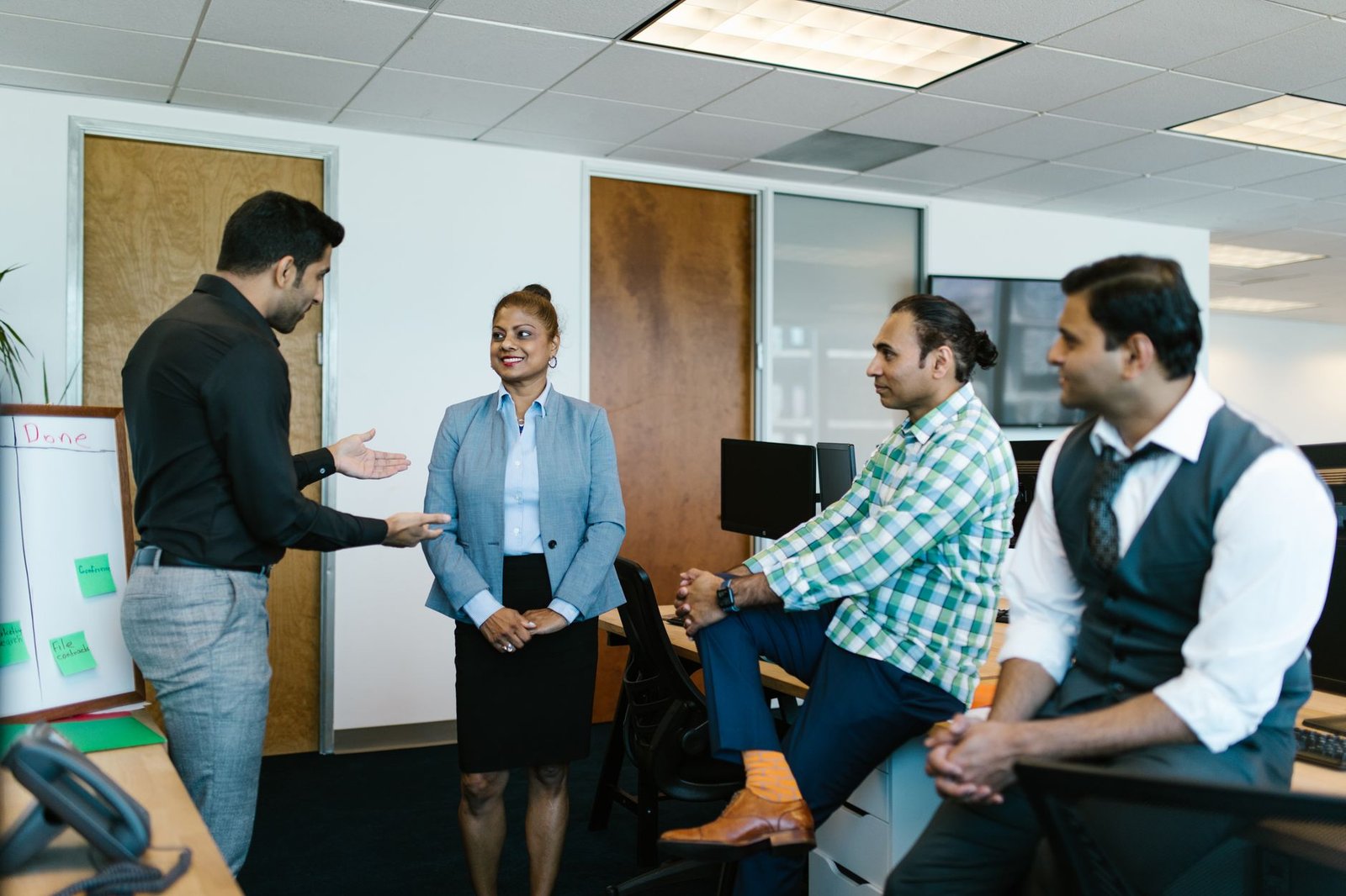 A diverse group of colleagues engaged in a collaborative meeting in a modern office setting.