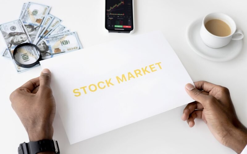 Business theme with stock market document, currency, and mobile display.