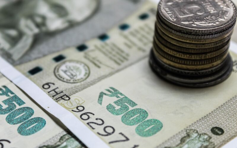 Detailed view of Indian rupees and stacked coins, representing currency and finance.