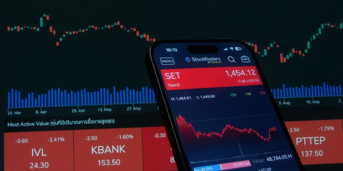 Mobile app showing stock market data with charts on screen.