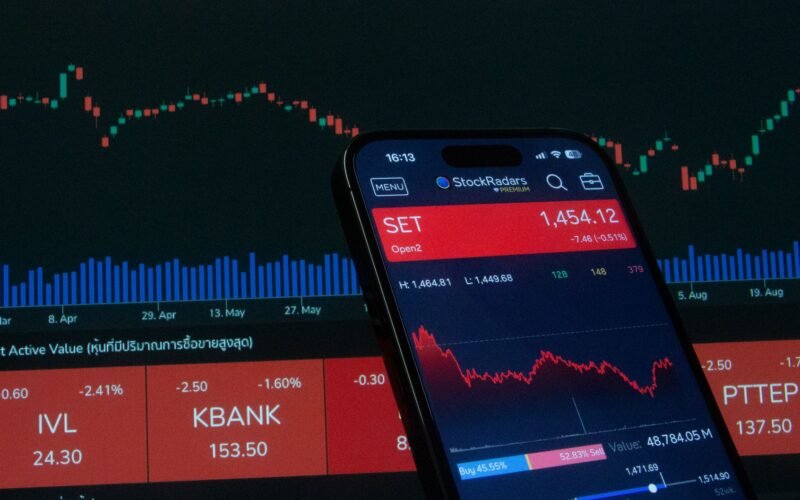 Mobile app showing stock market data with charts on screen.