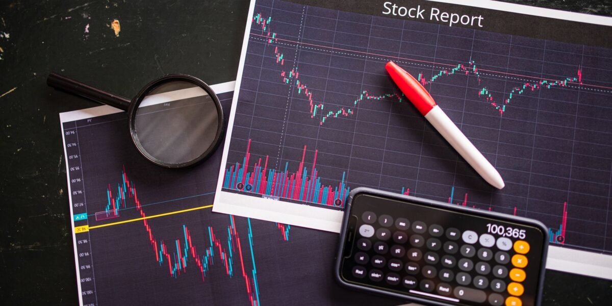 Stock report with charts, calculator, and magnifying glass for financial analysis.