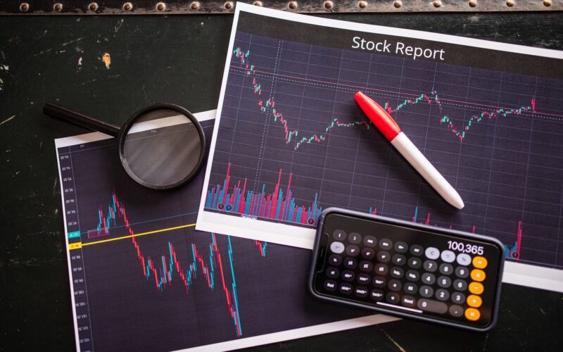 Stock report with charts, calculator, and magnifying glass for financial analysis.