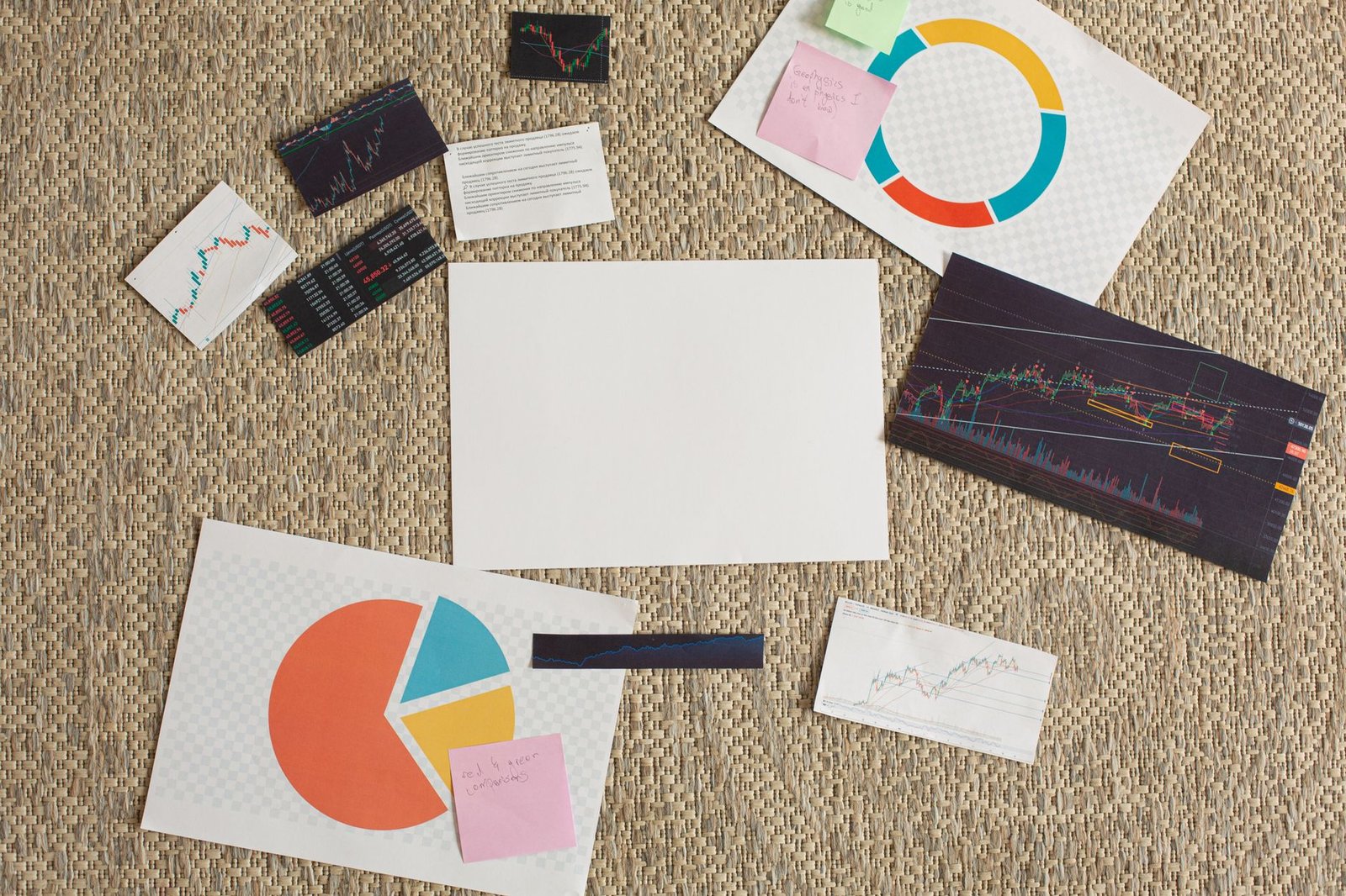 Flat lay of financial charts and sticky notes on a textured surface, ideal for planning and analysis concepts.