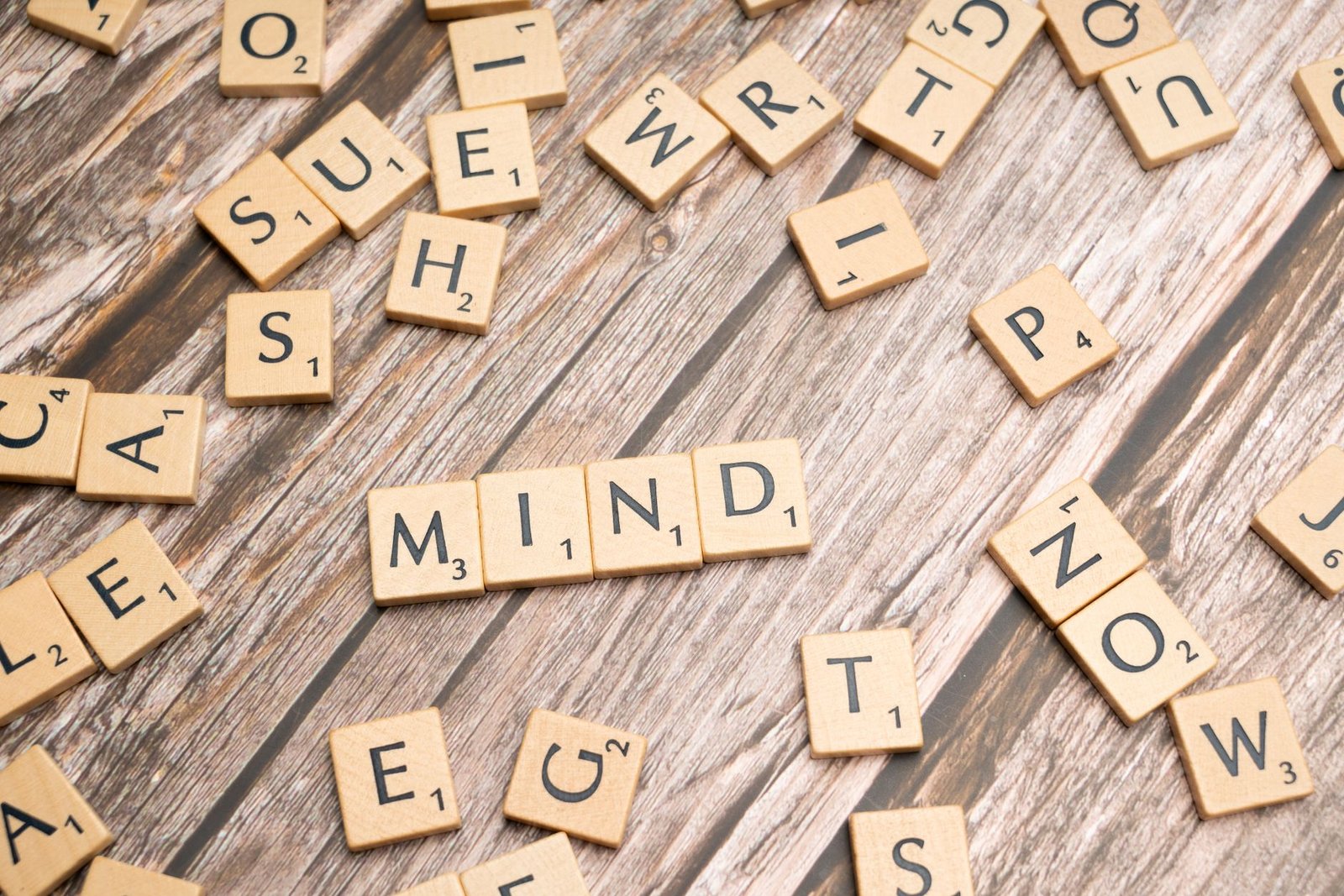 Scattered wooden letter tiles on a rustic wood surface highlighting the word 'Mind'. Ideal for mental and cognitive themes.