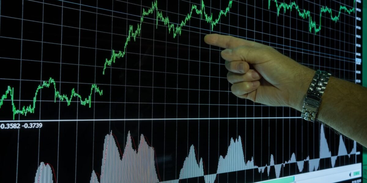 Graph showing financial data analysis with a hand pointing out market trends.