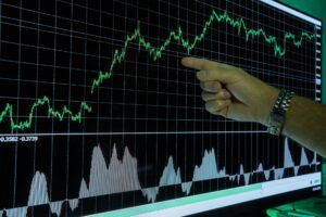 Graph showing financial data analysis with a hand pointing out market trends.