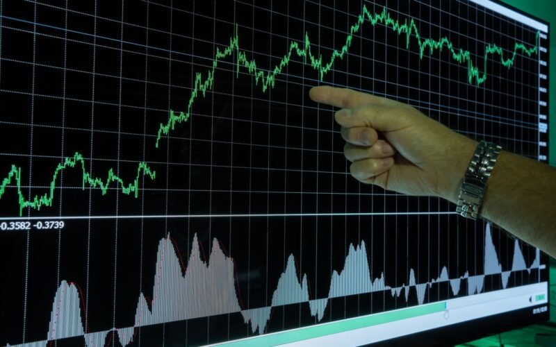 Graph showing financial data analysis with a hand pointing out market trends.