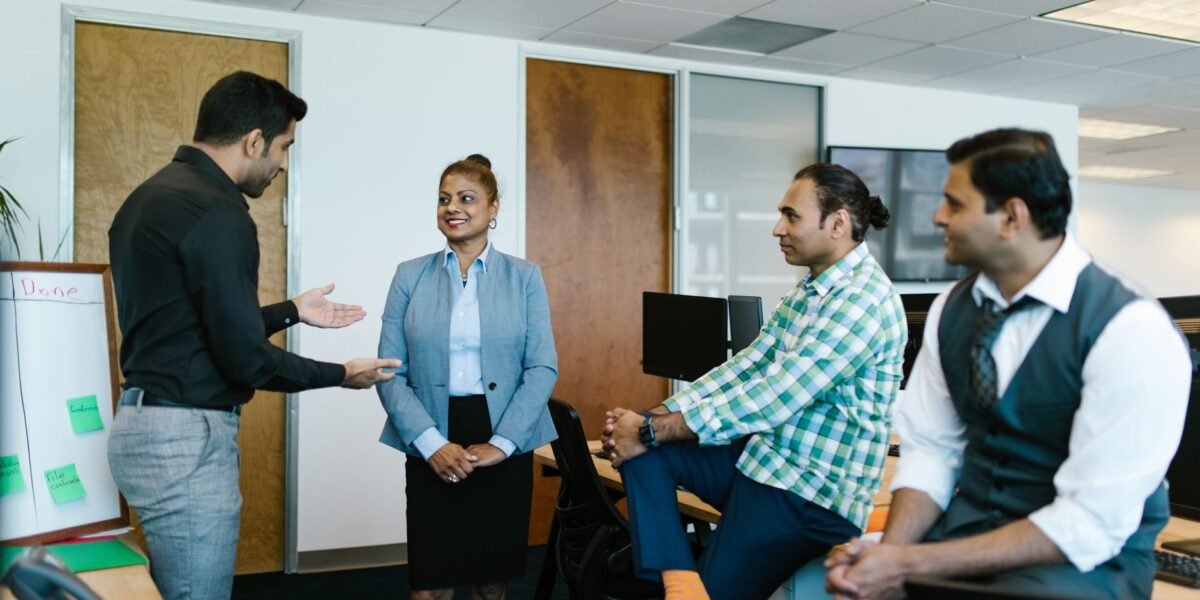 A diverse group of colleagues engaged in a collaborative meeting in a modern office setting.