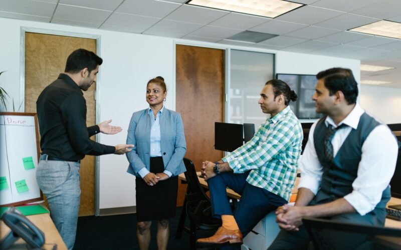 A diverse group of colleagues engaged in a collaborative meeting in a modern office setting.