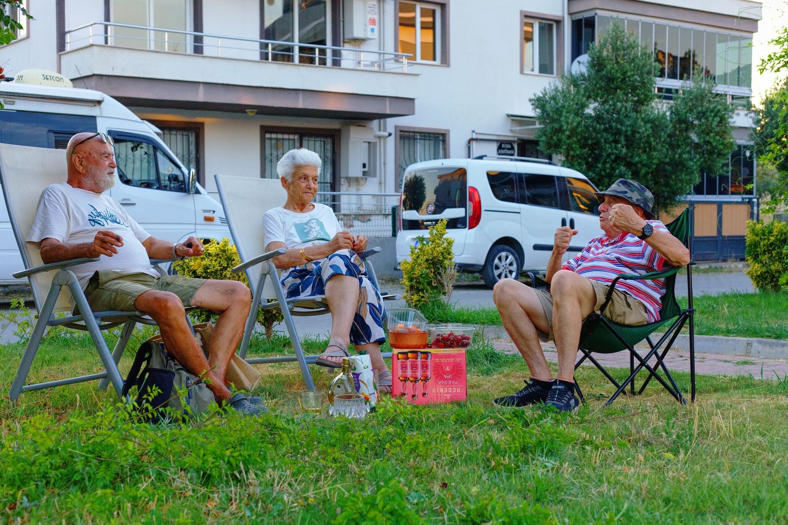 Group of senior adults relaxing in a garden, sharing stories and snacks outdoors in İzmir.