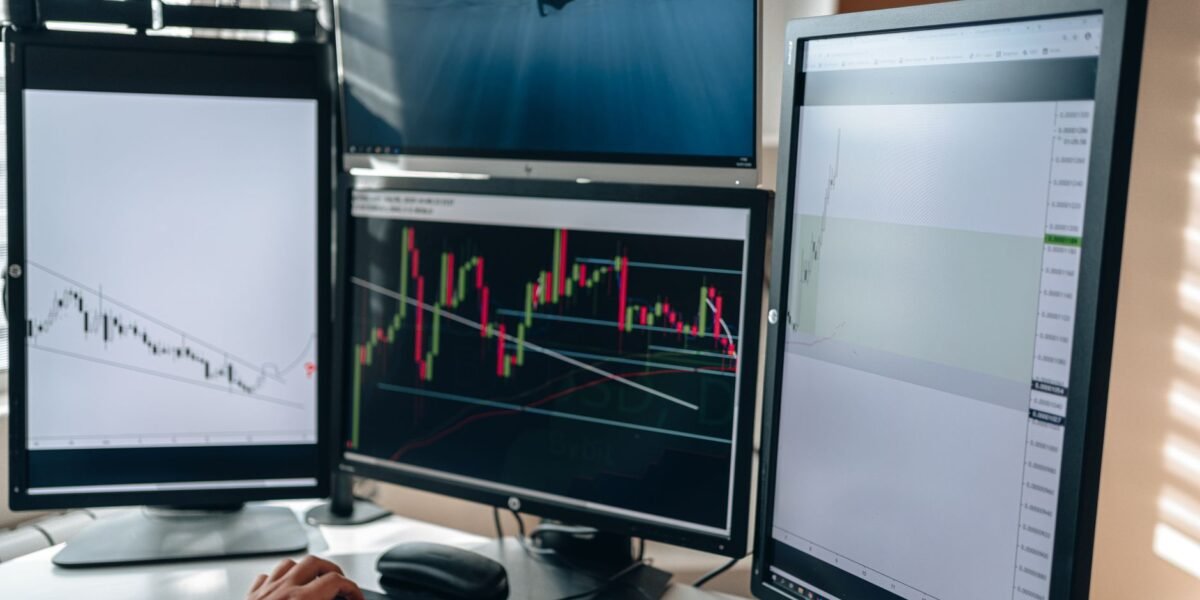 A multi-monitor stock trading setup showcasing charts and data analysis in a home office setting.