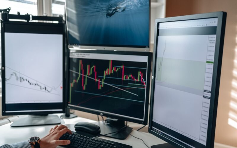 A multi-monitor stock trading setup showcasing charts and data analysis in a home office setting.
