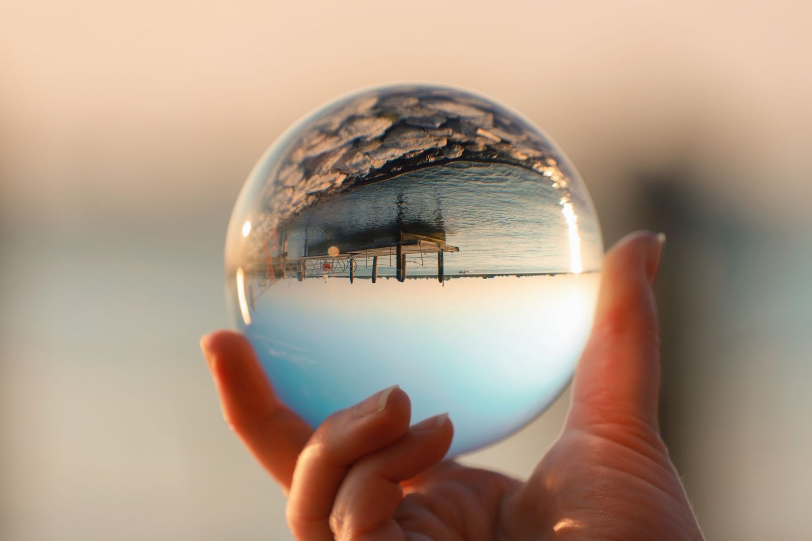A scenic lake view in Italy captured through a glass ball reflection, showcasing serene beauty.