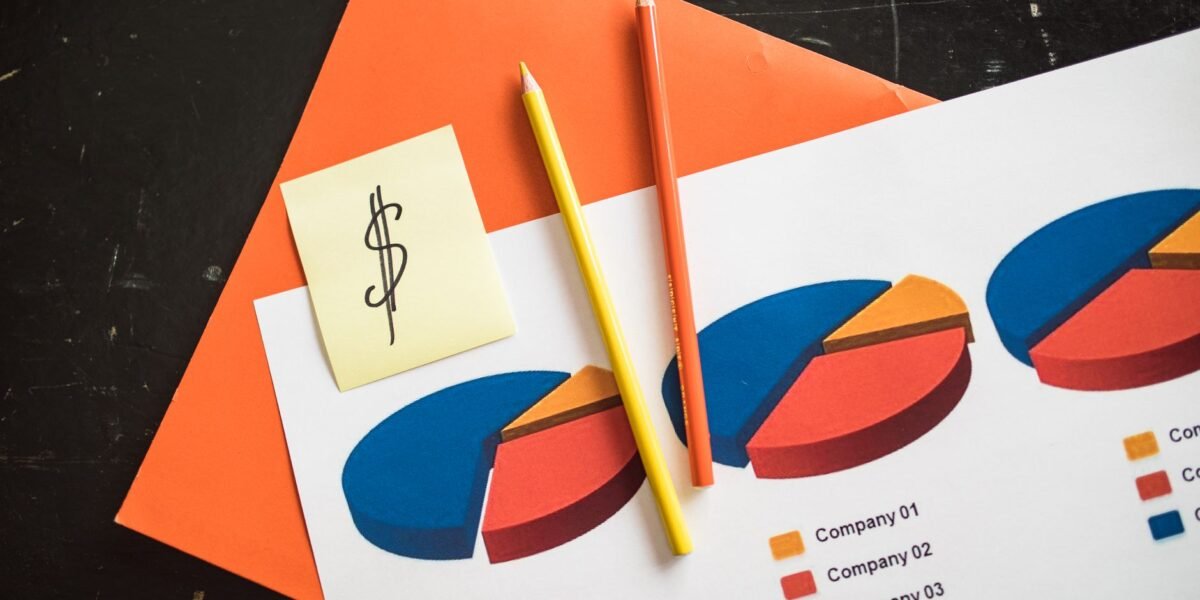 A creative arrangement of financial pie charts with colorful pencils and a dollar note, perfect for business themes.