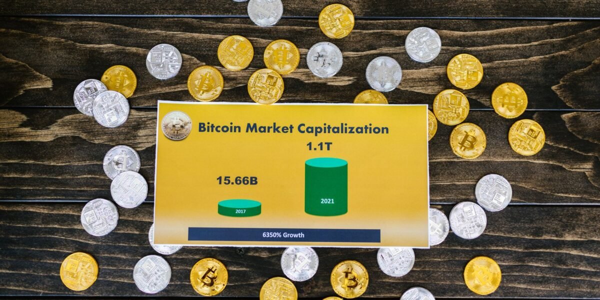 Bitcoin coins on wooden surface with chart showing market cap growth to 1.1T.