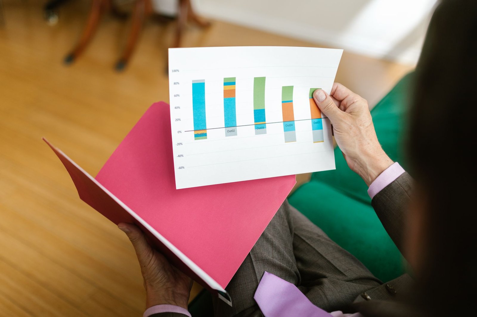 Close-up of a person analyzing a printed business report featuring a colorful bar graph.